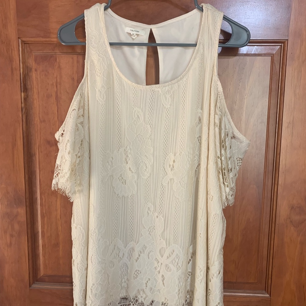 This is a cream lace shirt with arm straps.